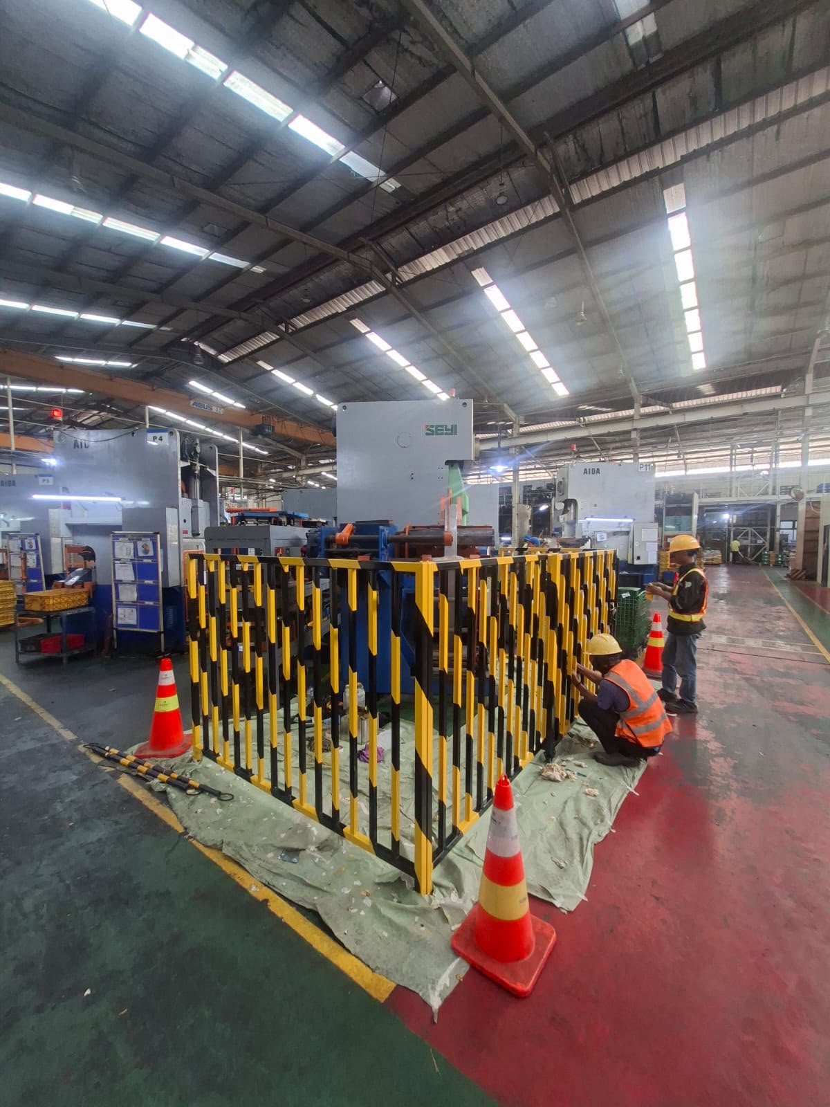 Proses instalasi safety fence di area produksi